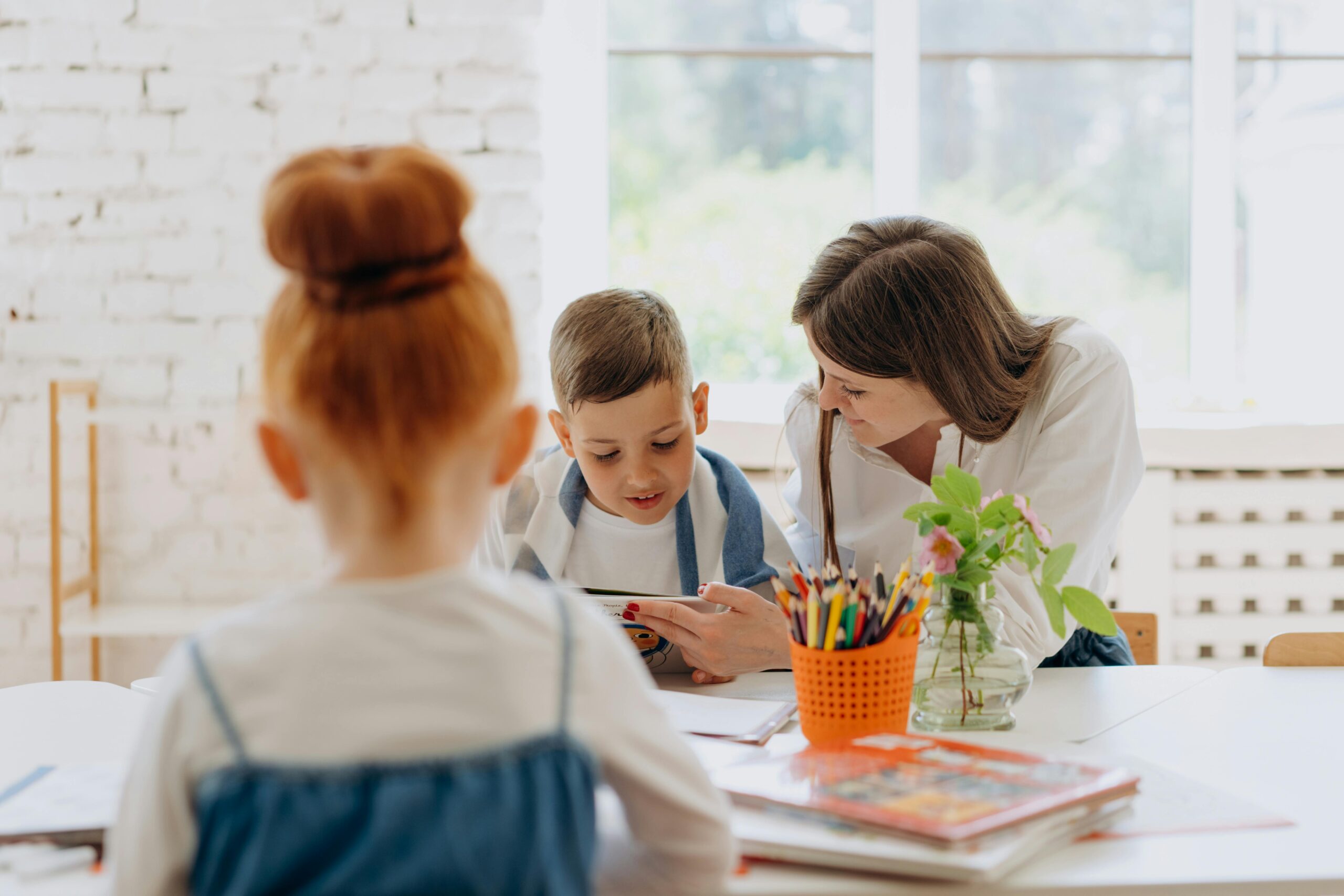 Engaging learning experience with a teacher and child exploring books and creativity in a bright classroom.
